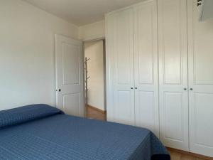 1 dormitorio con 1 cama azul y armarios blancos en Muy cómodo y trendy, en Montevideo