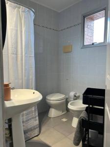 Baño blanco con aseo y lavamanos en Muy cómodo y trendy, en Montevideo