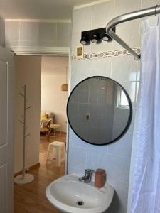 ein Bad mit einem Waschbecken und einem Wandspiegel in der Unterkunft Muy cómodo y trendy in Montevideo