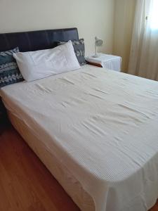 1 cama grande con sábanas y almohadas blancas en Canet Holiday, en Valencia