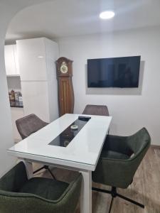 Habitación con mesa blanca, sillas y reloj en small apartment for two en Brus
