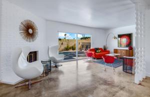 パーム・スプリングスにあるFunky & Retro Vibes - A Ryson Propertyのリビングルーム(白い椅子、暖炉付)