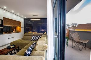 sala de estar con sofá y cocina en Penthouse Apartman Roko, en Virovitica