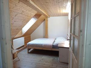 Bett in einem Zimmer mit Holzdecke in der Unterkunft Statek Hájek in Nišovice