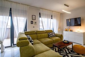a living room with a couch and a tv at Penthouse Apartman Roko in Virovitica