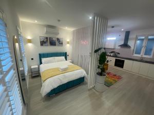 a bedroom with a bed and a kitchen at Stylish Studio in Colchester