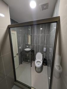 a small bathroom with a toilet and a sink at Hotel Abrego in San Salvador