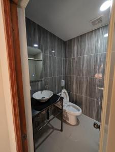 uma casa de banho com um lavatório e um WC em Hotel Abrego em San Salvador
