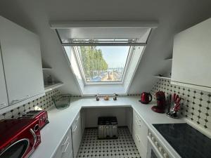 een kleine keuken met een raam en een wastafel bij Untersee - Appartements in Moos