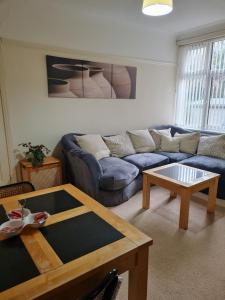 - un salon avec un canapé bleu et une table basse dans l'établissement Genade Apartments - Heaton, à Newcastle upon Tyne
