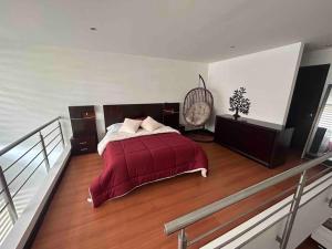 1 dormitorio con 1 cama con manta roja en Loft de Lujo todas las comodidades cerca de todo, en Quito