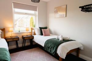 1 dormitorio con 2 camas y ventana en Bowling View - Stylish, Home from Home in Skipton, en Skipton
