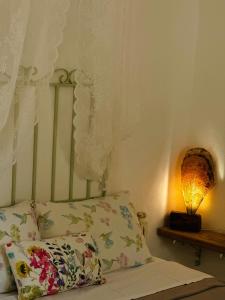 a bed with a pillow and a lamp on a table at Errika's Sweet Home in Provatas
