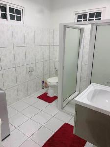 y baño con aseo, ducha y lavamanos. en Kapowlito Real Estate Casa Hoopweg, en Paramaribo
