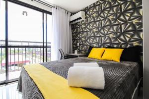 a bedroom with a large bed with yellow and black pillows at LF101 - Studio decorado no Tatuapé (Metrô a 250m) in Sao Paulo