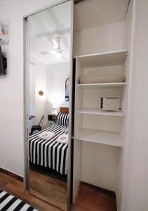 Dormitorio pequeño con cama y espejo en Apartamento España en Corrientes