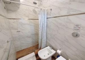 y baño blanco con ducha y aseo. en Apartamento España en Corrientes