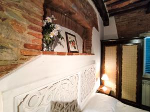 a bedroom with a bed and a brick wall at Giada Palace Group - Sweet City Center Apartment in Lucca