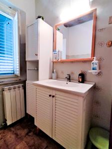 a bathroom with a white sink and a mirror at Giada Palace Group - Sweet City Center Apartment in Lucca
