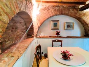 a table and chairs in a room with a brick wall at Giada Palace Group - Sweet City Center Apartment in Lucca