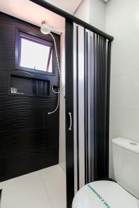 a bathroom with a black door and a toilet at LF101 - Studio decorado no Tatuapé (Metrô a 250m) in Sao Paulo