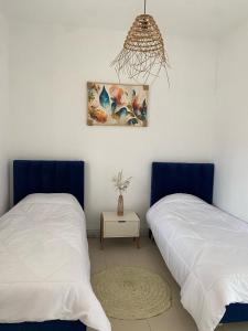 a bedroom with two beds and a picture on the wall at maison 4 saison in La Goulette