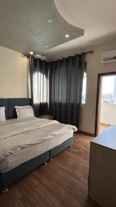 um quarto com uma cama grande e uma janela em شقق الرفيق الفندقية em Aqaba