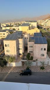 um carro preto estacionado em frente a um edifício com painéis solares em شقق الرفيق الفندقية em Aqaba
