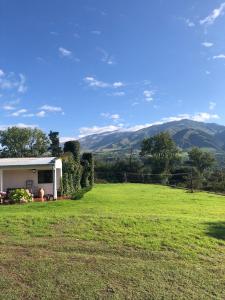 a house in a field with mountains in the background at Descanso Perfecto en Tafí del Valle in Tafí del Valle
