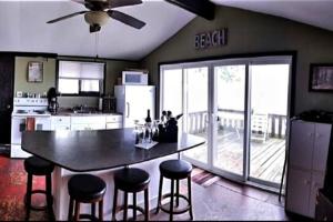 a kitchen with a table and stools in a room at West Lake Waterfront Swimming - Free Pontoon Boat! in West Lake
