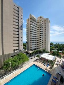 Blick auf zwei hohe Gebäude und einen Pool in der Unterkunft Espectacular apartamento Santa Marta se debe reservar almenos un día antes de llegar al apartamento in Santa Marta