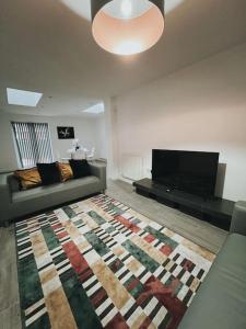 a living room with a couch and a rug at Oldbury Heritage Hideaway! in Birmingham