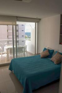 um quarto com uma cama azul e uma sala de jantar em Espectacular apartamento Santa Marta se debe reservar almenos un día antes de llegar al apartamento em Santa Marta