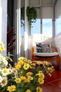 um ramo de flores amarelas e brancas num alpendre em Judith House - Amadora Este na Amadora