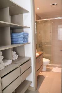 ein Bad mit einer Dusche, einem WC und Handtüchern in der Unterkunft Espectacular apartamento Santa Marta se debe reservar almenos un día antes de llegar al apartamento in Santa Marta