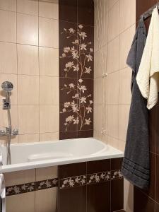 a bathroom with a bath tub with a flower pattern on the wall at APARTAMENT CENTRUM in Nowe Miasto Lubawskie