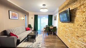 a living room with a couch and a brick wall at Casa Ama in Buşteni