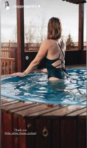 a woman is sitting in a swimming pool at The White House in Reykholt