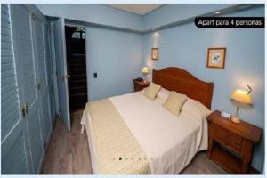 a bedroom with a white bed and a blue wall at Bahia Manzano Resort in Villa La Angostura