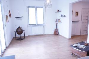 a living room with white walls and a wooden floor at Casa Bellavista-Spazioso appartamento in collina a due passi da Bergamo in Sorisole