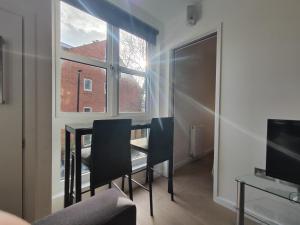 um quarto com uma mesa e duas cadeiras e uma janela em Modern 1 Bed Apartment Camden em Londres