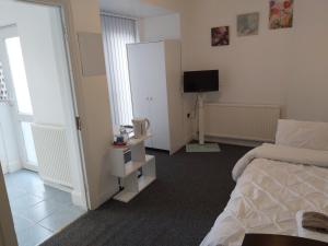 ein Hotelzimmer mit einem Bett, einem TV und einem Schlafzimmer in der Unterkunft Fresher Space Home Stay in Birmingham