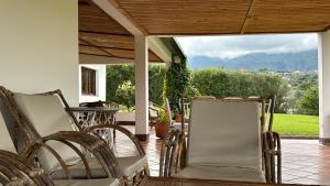 a porch with chairs and a table and mountains at Descanso Perfecto en Tafí del Valle in Tafí del Valle