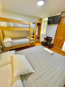a bedroom with two bunk beds and a flat screen tv at Jultom Inn Hotel & Suites in Trujillo