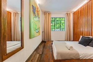1 dormitorio con cama y espejo en Espaciosa y Lujosa Casa en la Condesa con Roof Top en Ciudad de México