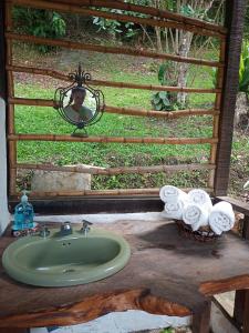 a bathroom sink with towels on a wooden counter at Eco-Cabañas Altozano Nimaima in Nimaima