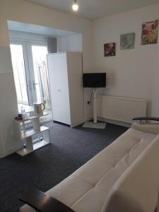 a living room with a white couch and a television at Fresher Space Home Stay in Birmingham
