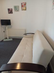 ein weißes Sofa in einem Zimmer mit einem TV in der Unterkunft Fresher Space Home Stay in Birmingham