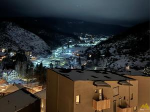 a view of a city at night with snow covered mountains at Mihail Apartments Mavrovo in Mavrovo