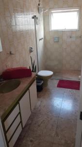 La salle de bains est pourvue de toilettes, d'un lavabo et d'une douche. dans l'établissement Suíte em São Paulo, à São Paulo